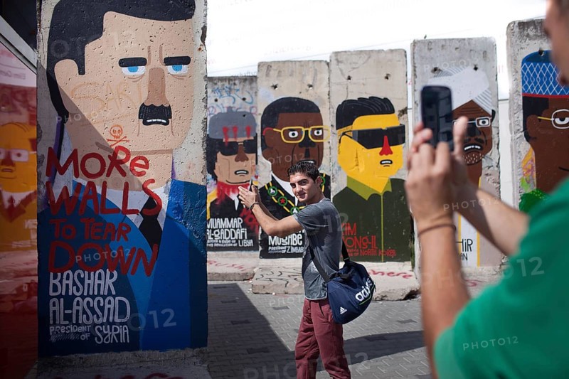 DEU Germany Germany Berlin A tourist has himself photographed shooting in front of Syrian dictator Bashar Al-Assad