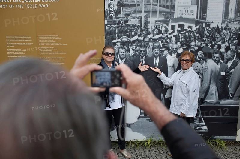 DEU Germany Germany Berlin tourist photographs friends with JF Kennedy and Willy Brandt at Checkpoint Charlie