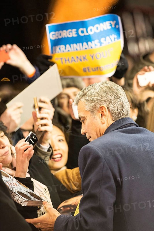 DEU Germany Germany Berlin 64th Berlinale, the international film festival in the German capital. The director of the films 'Monuments Men' George Clooney signs autographs. In the background, a banner on which Ukraine thanks him for his commitment
