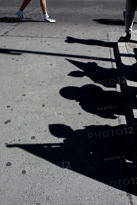 DEU Germany Germany Berlin tourists at Checkpoint Charlie. Shadows of extras disguised as soldiers and their flags