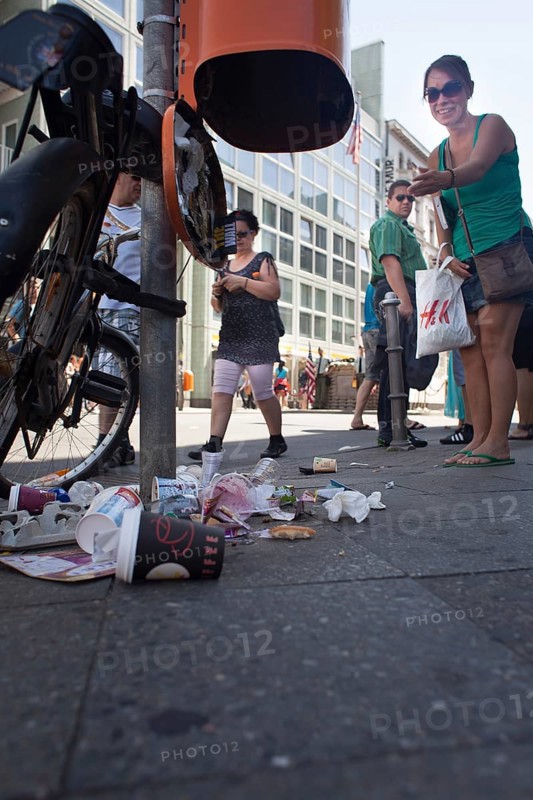DEU Germany Germany Berlin tourist points to defective trash can at Checkpoint Charlie