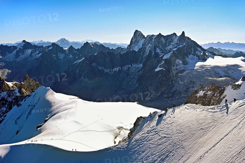 Mountaineers climb over a snow-covered mountain ridge, behind Grandes Jorasses, viewing platform, mountain station, Aiguille du Midi, Chamonix-Mont-Blanc, Haute-Savoie, France
