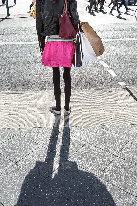 DEU Germany Germany Berlin A woman with shopping bags waits at a pedestrian traffic light on Potsdamer Platz