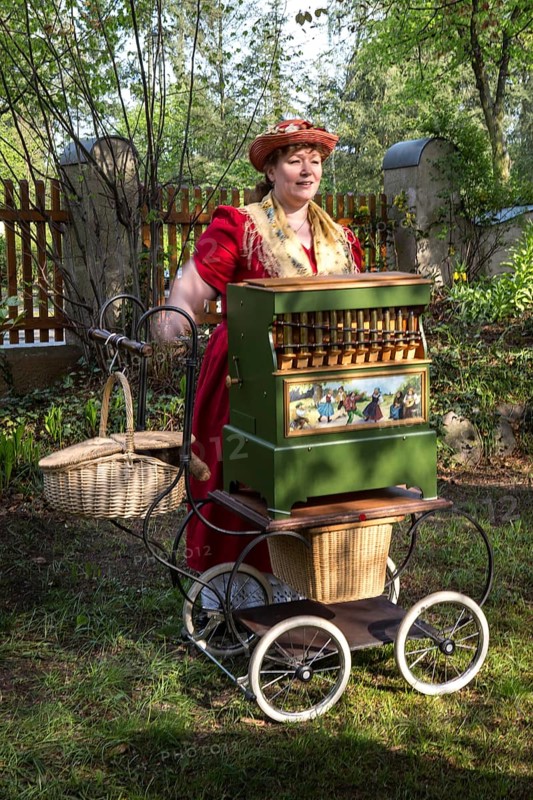 DEU Germany Germany Berlin An organ box woman plays for wedding guests during a reception in the garden