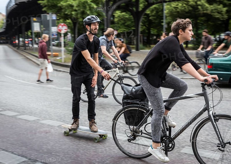 DEU Germany Germany Berlin female cyclist pulls skateboarders on Skalitzer Straße in Kreuzberg