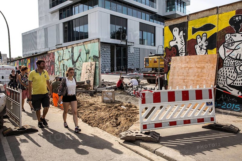 DEU Germany Germany Berlin Tourists pass through the opening in the East-Side Gallery, which was built for a new building. The removal of the piece of wall for the construction of the luxury property directly on the Spree behind the wall led to fierce protests among the population