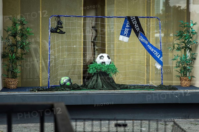 DEU Germany Germany Berlin Display of a discount funeral home on Bundesallee. Ball as an urn for the soccer fan from Hertha BSC Berlin