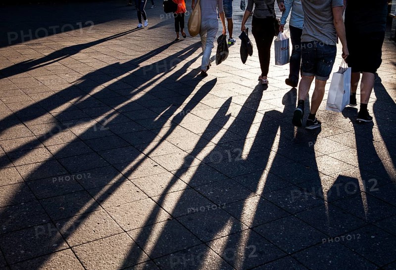 DEU Germany Germany Berlin People with shopping bags cast their shadows on the sidewalk of the cow dam