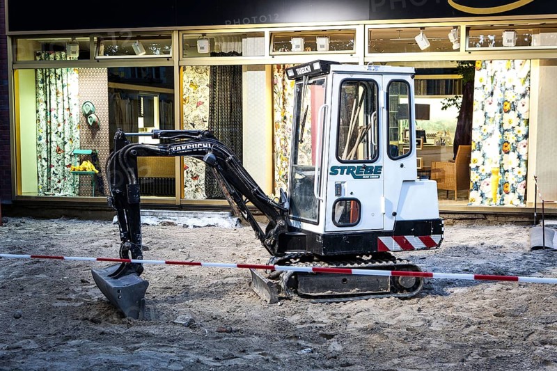 DEU Germany Germany Berlin A small excavator stands in front of an interior decoration shop