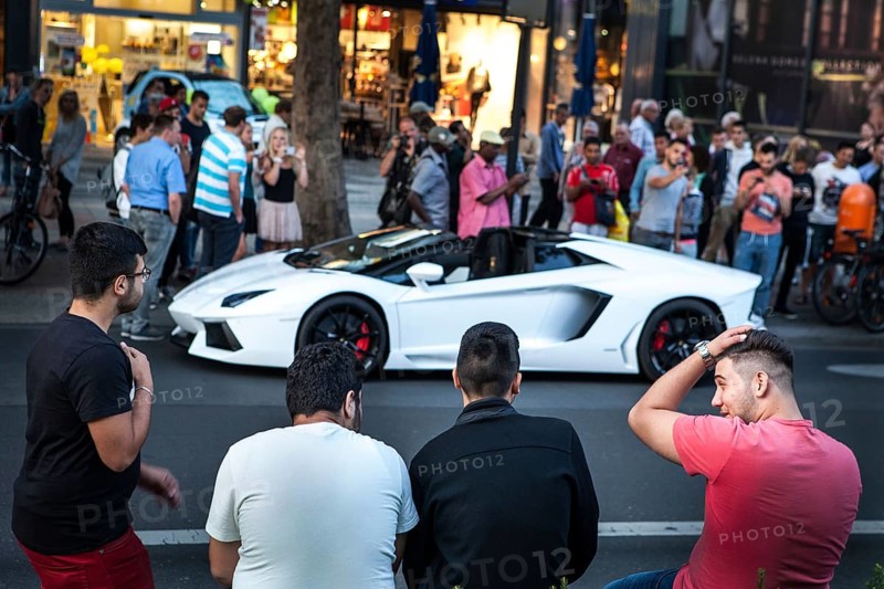 DEU Germany Germany Berlin A Lamborghini sports car is observed or photographed by passers-by on the Tauentzien. The driver got into a police checkpoint. Young people admire the luxury car from a distance