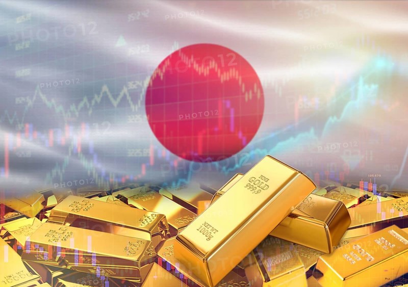 Gold bars on Japan flag in background. Gold bars stacked on Japanese flag. Concept of Japan gold reserves