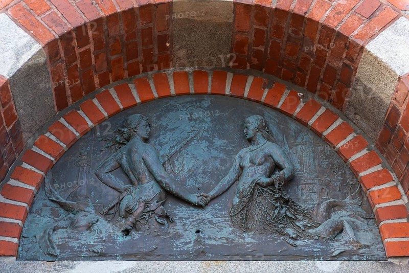 Lighthouse, access to the Kiel Canal, NOK, relief above the front door, symbol, mermaids of the North Sea and Baltic Sea shake hands, fishing net, fish, water, semicircle, lake ponds, Kiel Fjord, Holtenau district, Schleswig-Holstein, Germany