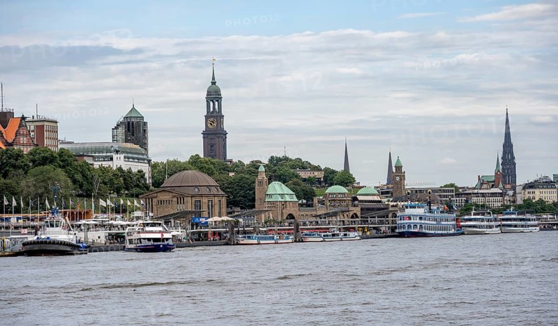Elbe and boats at the St. Pauli piers, historic building with a level tower, in the back church tower of the church of St. Michaelis, Hamburg, Germany