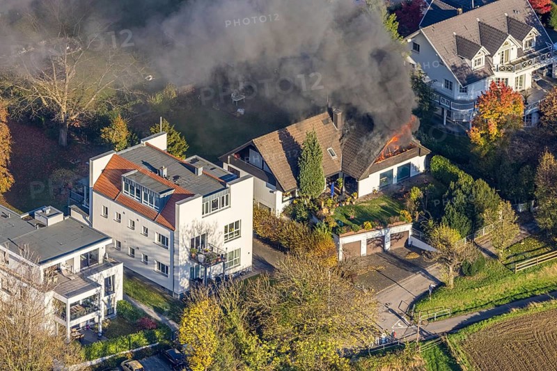 Several callers reported a fire with heavy smoke on Bergerstraße in Mülheim-Menden at 2.57 pm today, Saturday. When the first emergency services arrived, they discovered that the roof truss of a two-storey residential building was fully engulfed in flames. Due to the expected long and intensive operation, a full alarm was immediately sounded for the volunteer fire brigade. There were no residents in the house. Firefighters from the professional fire brigade immediately began fighting the fire from the inside and using a turntable ladder. As the operation progressed, they were supported by colleagues from the Heißen fire brigade of the volunteer fire brigade. Once the actual fire had been extinguished, the post-extinguishing work proved to be quite complex and lengthy. Parts of the roof have to be removed in order to reach any remaining embers. The ongoing operation involved two fire engines, several special and command vehicles from the professional fire brigade as well as vehicles fro...