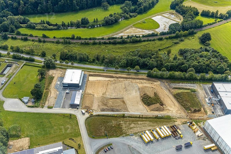 Aerial view, construction site new building Lausberg Kunststofftechnik, industrial estate Meschede-Enste, Am Heerweg, Meschede, Sauerland, Hochsauerlandkreis, North Rhine-Westphalia, Germany, construction work, construction area, building site, building plots, construction project, construction site, Caritas-Werkstätten Meschede, DE, Europe, commercial enterprises, commercial area, commercial park, commercial site, commercial use, industrial area, industrial site, L743 state road, Lausberg, Lausberg Kunststofftechnik, aerial photograph, aerial photography, aerial photography, MÖNIG Spedition, new building, R.A.B.E. waste processing, overview, bird's-eye view, birds-eyes view, overview