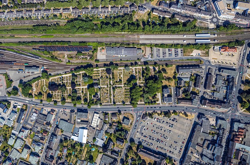 Aerial view, centre of Mörs, former goods station, railway tracks, cemetery Mörs, miners' settlement Moseler Straße, Lippestraße, Marienburger Straße, backyard, allotment gardens, historic miners' settlement, Meerbeck, Mörs, Ruhr area, North Rhine-Westphalia, Germany, DE, Europe, birds-eyes, view, aerial view, aerial photography, aerial photography, overview, overview, bird's-eye view, living, flat, houses, residential buildings, housing estate, settlement, railway line, railway network, infrastructure, traffic, train traffic, freight traffic, railway network, funeral, burial, funeral service, farewell, green area, mourning, green space, commemoration