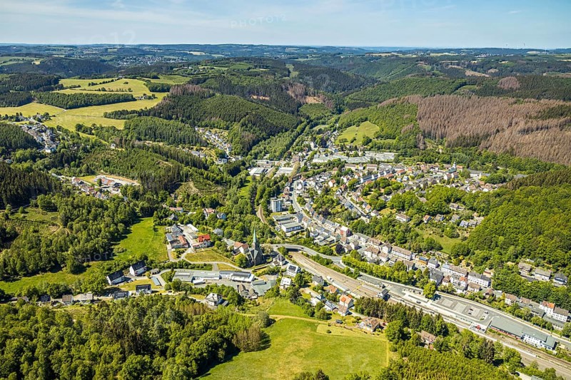 Aerial view, Brügge district, Lüdenscheid-Brügge railway station, Lüdenscheid fire brigade, Brügge equipment depot, Evang. Kreuzkirche Brügge, Lüdenscheid, Märkischer Kreis, Sauerland, North Rhine-Westphalia, Germany, place of worship, railway tracks, railway station, station forecourt, fire fighter, fire protection, fire station, bridge signal box, federal road B54, DE, Deutsche Bahn AG, Europe, distant view, fire engine, fire brigade, fire station, fire engine, commercial area, commercial use, religious community, place of worship, property tax, green trees, hilly landscape, real estate, church, parish, denomination, district town, aerial view, aerial photography, aerial photography, fire engine, tenement houses, religion, separation station, overview, bird's eye view, Volmetalbahn, meadows and fields, living and life, residential buildings, birds-eyes view, green lung, overview