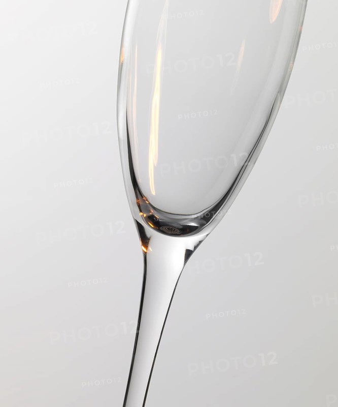 Studio photography of a champagne glass detail with warm light reflections