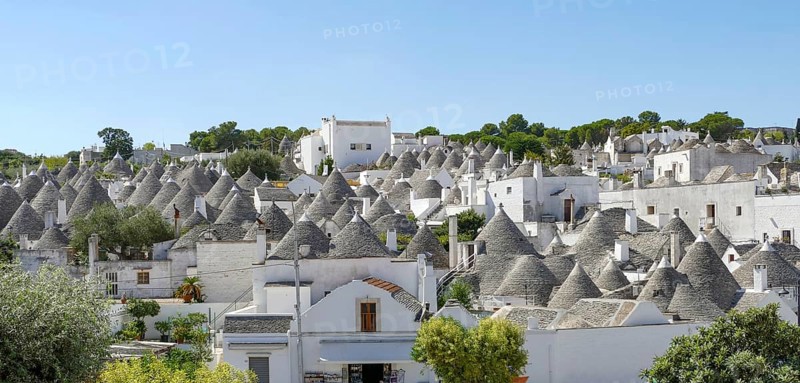 Sunny impression of trulli houses at a town named Alberobello in Apulia, Italy