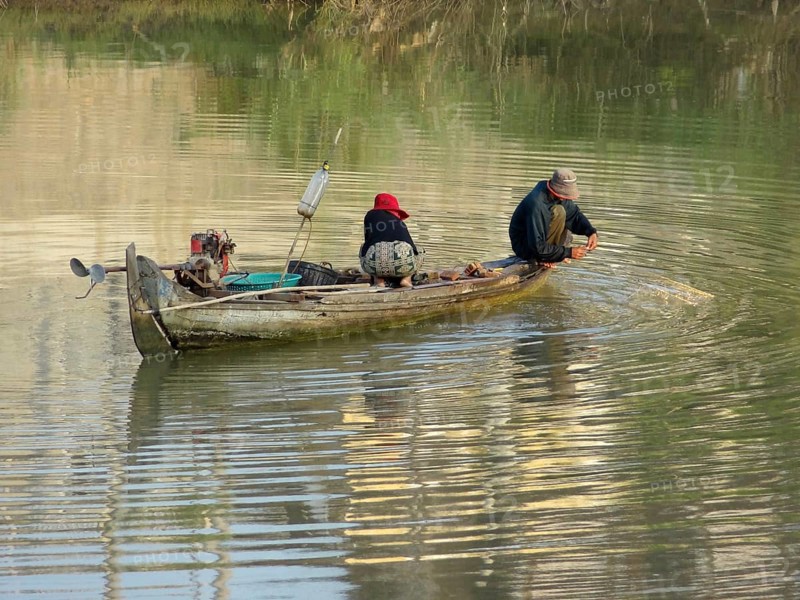 Riparian scenery with small boat at a river in Cambodia