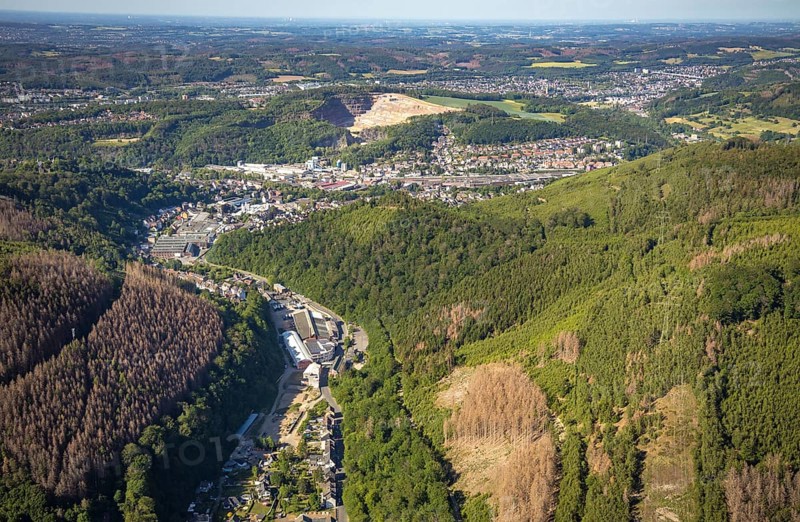Aerial view, planned wind power plants, industrial area Obernahmerstraße, district Nahmer, quarry Steltenberg, Hagen-Hohenlimburg, Ruhr area, North Rhine-Westphalia, Germany, forestation, DE, Europe, distant view, commercial enterprises, commercial area, commercial site, commercial use, Hagen, Hohenlimburger Kalkwerke GmbH, hilly landscape, industrial area, industrial site, landscape conservation area, aerial view, aerial photography, aerial photography, nature conservation, nature reserve, quarry, open-cast mine, valley, overview, bird's-eye view, forest, forest area, forest damage, forest dieback, birds-eyes view, overview, thyssenkrupp Hohenlimburg GmbH