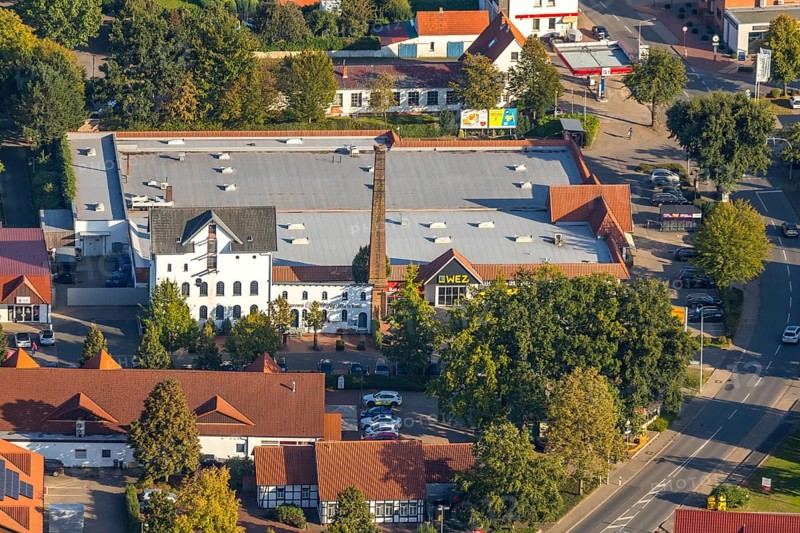 Aerial photograph, WEZ supermarket, stork's nest on the chimney of the Alte Kornbrennerei, Hille, Ostwestfalen-Lippe, OWL, North Rhine-Westphalia, Germany, Alte Brennerei, DE, shopping square, shopping centre, Europe, Hillerichs, industrial museum, Kornbrennerei Meyer, aerial photograph, aerial photography, aerial photography, Mindener Straße, museum, local shopping centre, nest, OWL book, OWLBuch, Ostwestfalenbuch, chimneys, shopping centre, StorchenLeben, supermarket, tower, overview, bird's-eye view, white storks, birds-eyes view, overview