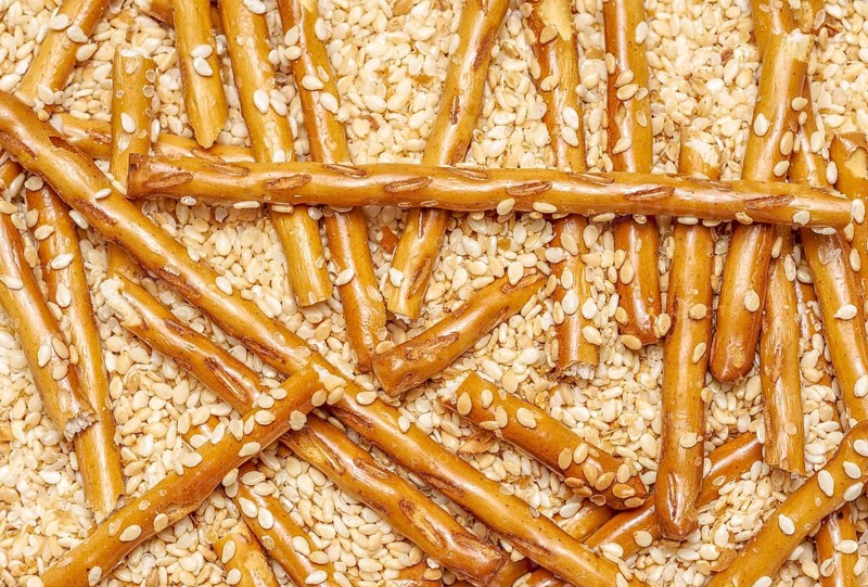 Full frame closeup of some baked sesame sticks in sesame back