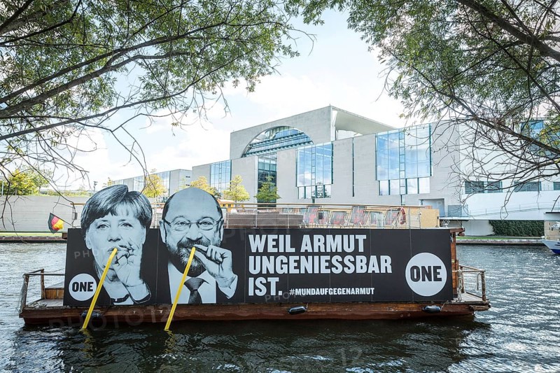 DEU Germany Germany Berlin Action by ONE on the Spree for the Bundestag elections. Protest against poverty with the likenesses of Merkel and Schulz drinking from the Spree with straws