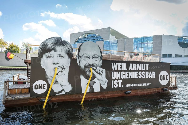 DEU Germany Germany Berlin Action by ONE on the Spree for the Bundestag elections. Protest against poverty with the confections of Merkel and Schulz drinking from the Spree with straws