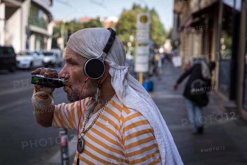 DEU Germany Germany Berlin A homeless man holds his mobile phone and a book in his hand