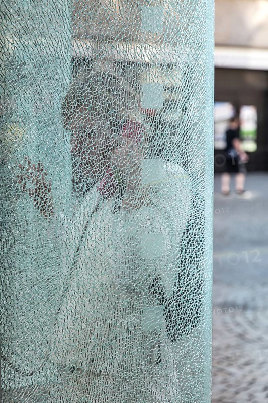 DEU Germany Germany Berlin Woman talking on the phone at a phone box with shattered glass in Berlin-Spandau
