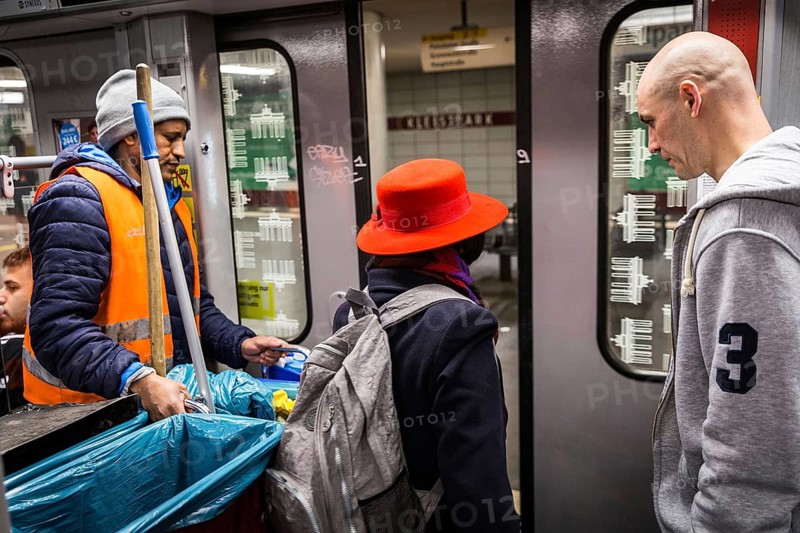 DEU Germany Germany Berlin Two men frame a woman leaving the U7 underground line at Kleistpark wearing a hat
