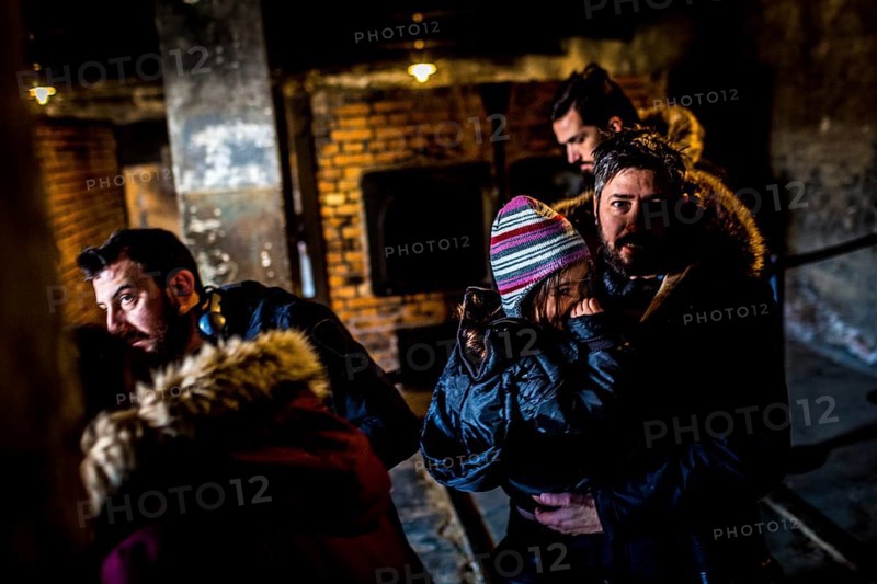 POL Poland Auschwitz Photo series about the memorial site of the former Auschwitz-Birkenau concentration camp. Father and his daughter leaving the oven next to the gas chamber. POL Poland Auschwitz Scenes at the Holocaust Memorial .Father and his daughter leaving the oven next to the gas chamber.Each year more than 2 million visitors are touring through the remains of the former German Nazi concentration and extermination camp Auschwitz-Birkenau. More than 1, 1 million people have been killed here between 1940 and 1945