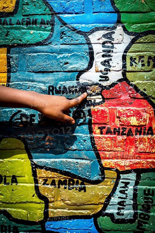RWA RWANDA Rwanda Gahini A pupil shows Rwanda on a map of Africa painted on the wall