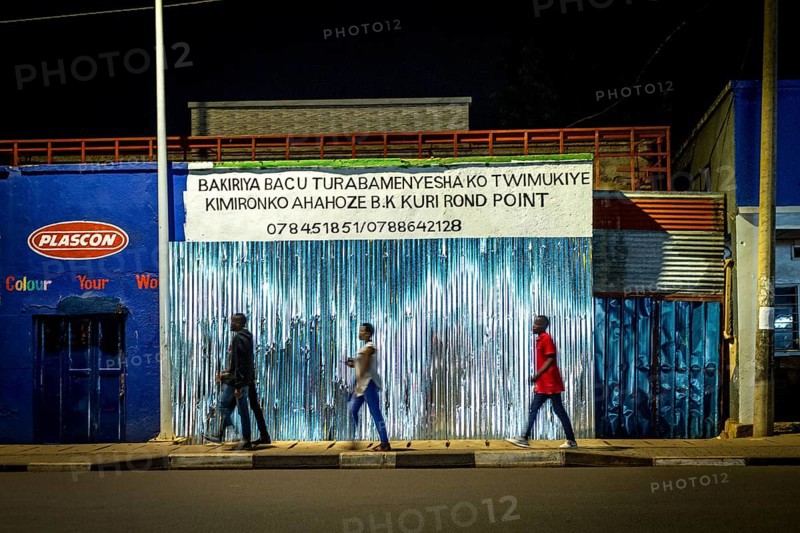 RWA RWANDA Rwanda Kigali people pass closed shops at night