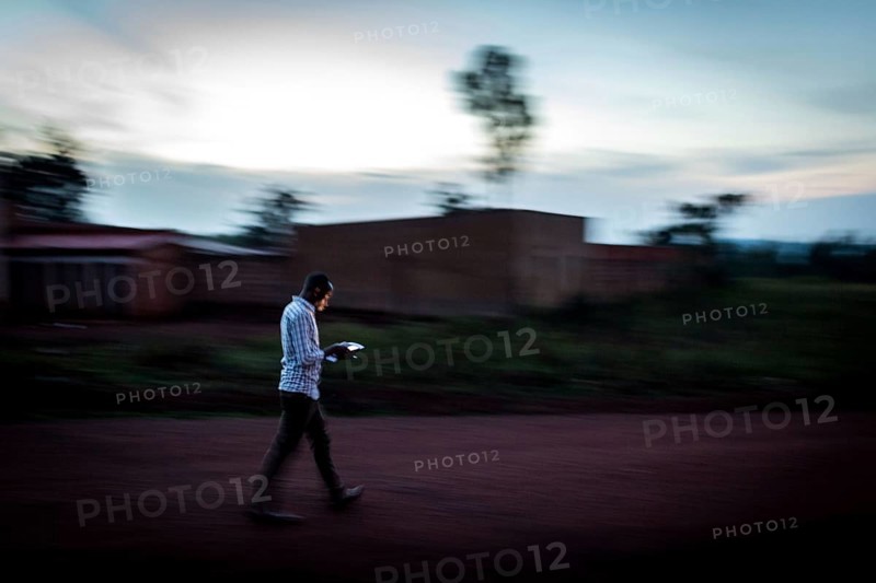RWA RWANDA Rwanda Rukara A student looks at his smartphone while walking