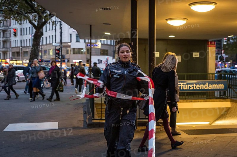 DEU Germany Germany Berlin Fire brigade operation on Kurfürstendamm. Storm Xavier had caused trees to fall onto the street. Policewoman lifts the underground barrier