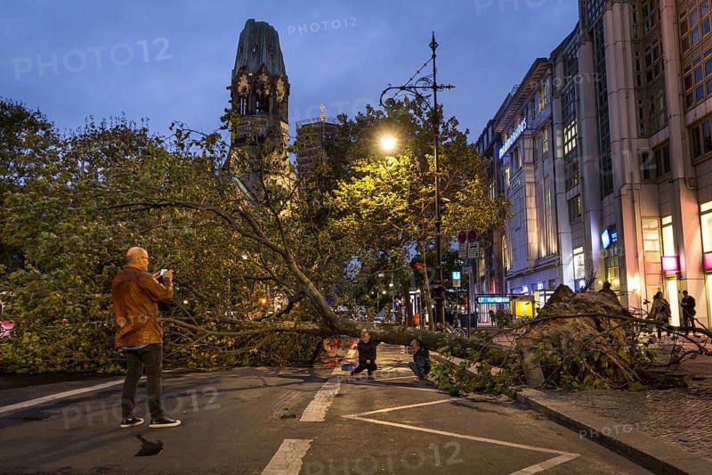DEU Germany Germany Berlin Fire brigade operation on Kurfürstendamm. Storm Xavier had caused trees to fall onto the street. Father takes a souvenir photo with his children