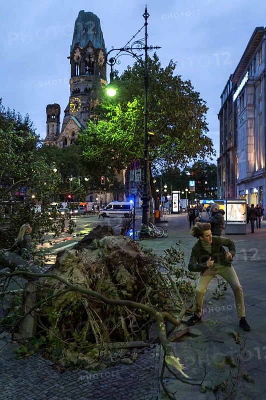 DEU Germany Germany Berlin Fire brigade operation on Kurfürstendamm. Storm Xavier had caused trees to fall onto the street. Passers-by pose for souvenir photos