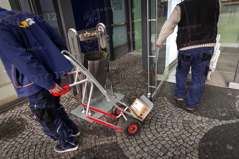DEU Germany Germany Berlin A courier with grocery orders enters the Europe Centre while a parcel courier leaves