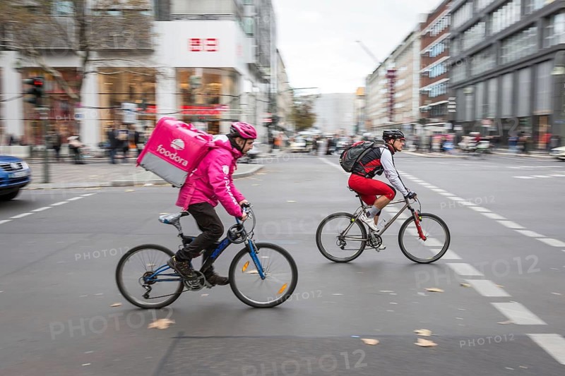 DEU Germany Germany Berlin A bicycle courier from Foodora starts off together with a cyclist at a traffic light on Tauenzien