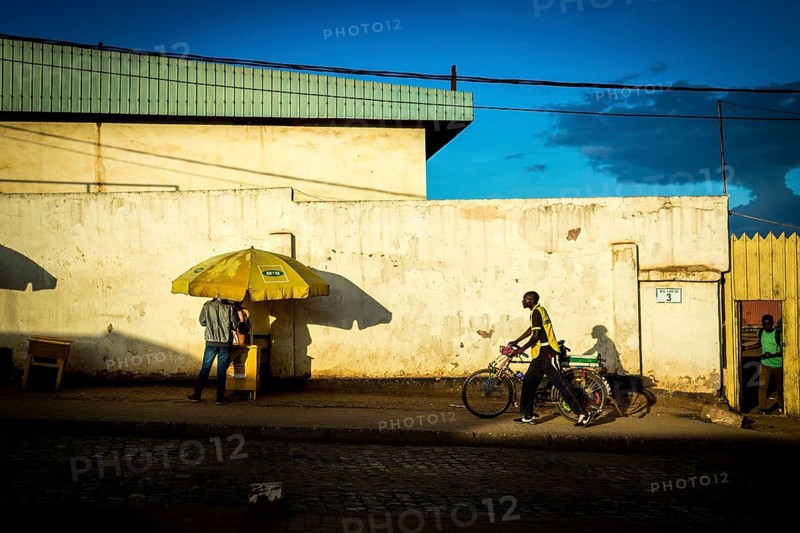 RWA RWANDA RUANDA Kigali A cyclist and a parasol cast their shadows on the wall