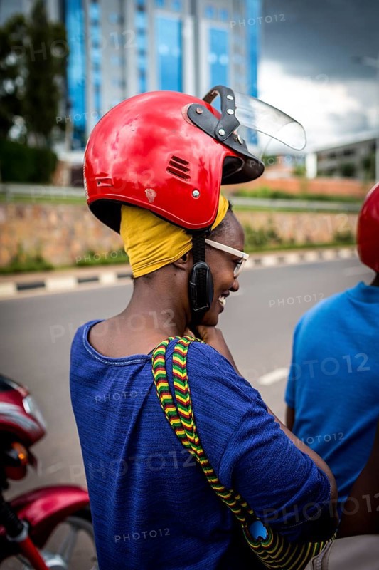 RWA RWANDA RUANDA Kigali A woman with a high hairstyle locks her helmet in front of taking a taxi on a motorbike
