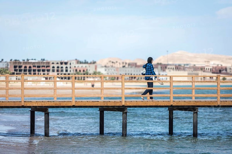Egypt Hurghada A Muslim woman on a footbridge against the backdrop of unfinished hotel complexes