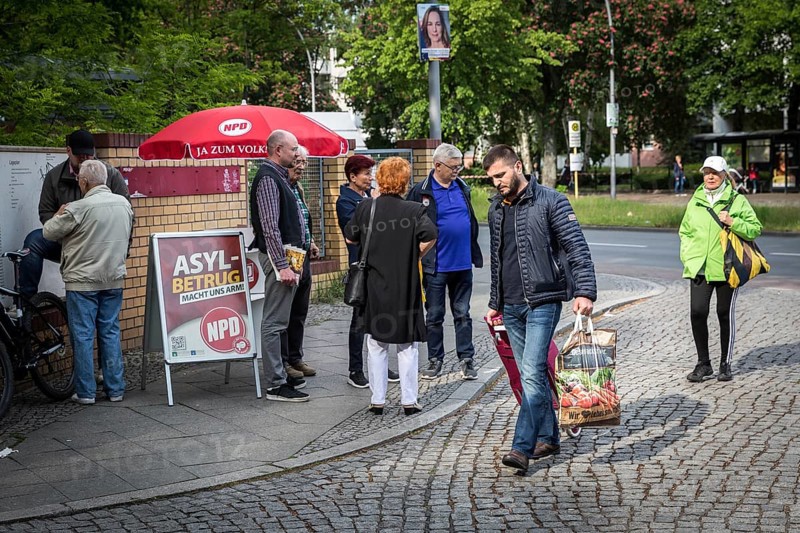 DEU Germany Germany Berlin Open day for the presentation of a new anchor centre on the grounds of the Karl Bonhoeffer mental hospital in Reinickendorf Migrants pass an NPD stand