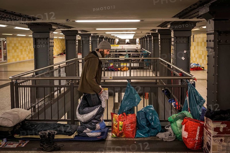 DEU Germany Germany Berlin Homeless people spend the night in a passageway at Lichtenberg underground station. Like Moritzplatz, the station has been made available by the BVG for overnight stays during the winter months.homeless man gets into his sleeping bag