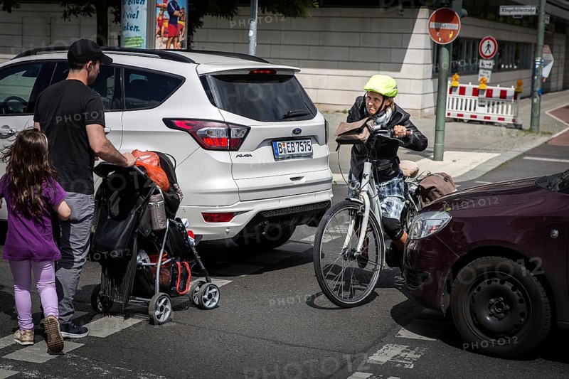 DEU Germany Germany Berlin Cyclist and pedestrian queue through heavy traffic on Klingenhoeferstrasse