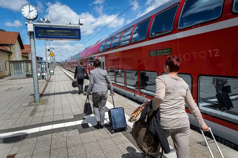 DEU Germany Germany Neubrandenburg Passengers with wheeled suitcases in front of boarding a regional train