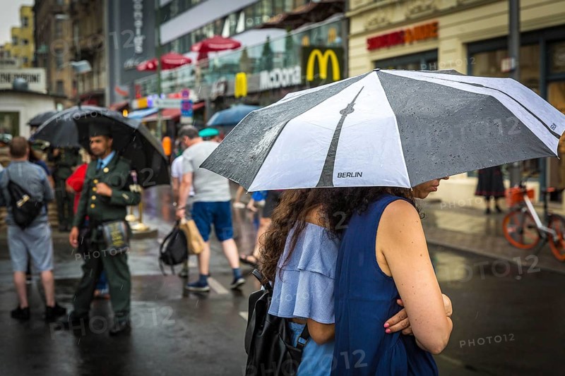 DEU Germany Germany Berlin Tourists with umbrellas at Checkpoint Charlie
