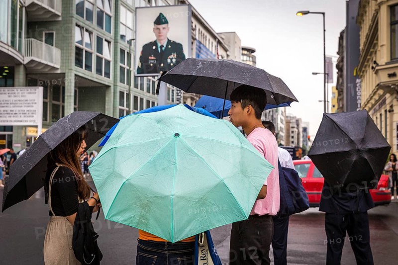 DEU Germany Germany Berlin Tourists with umbrellas at Checkpoint Charlie